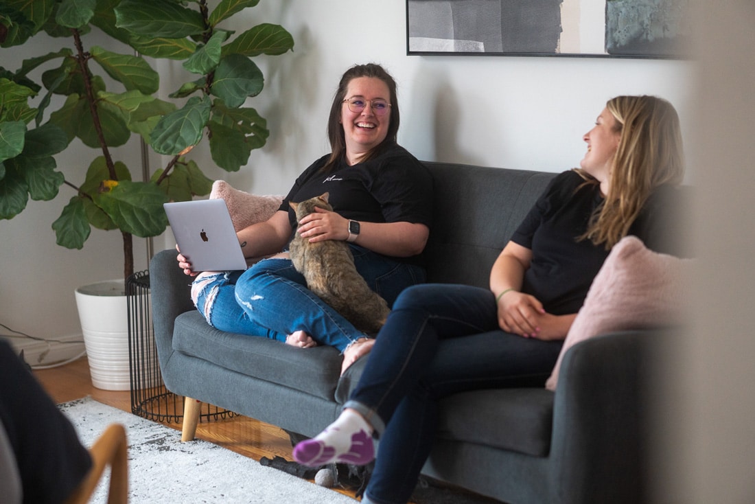 Two woman in an office setting with a laptop with property management software on it