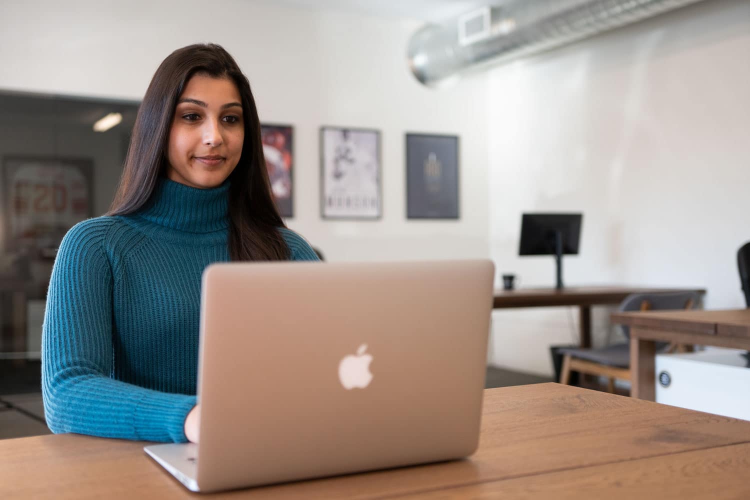 A woman in a property management office using a laptop